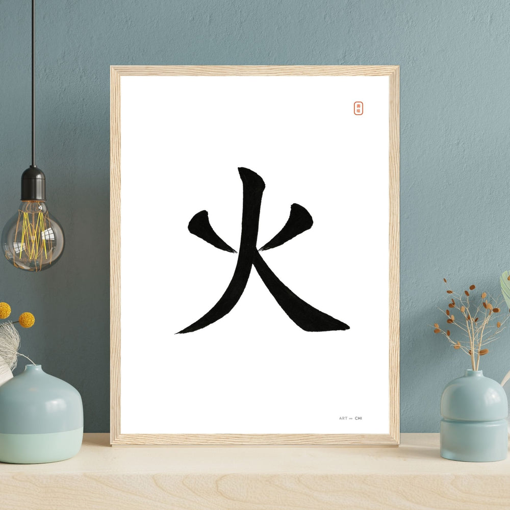 Carácter chino «火» (fuego) en tinta negra sobre fondo blanco, sello rojo y marco de madera.