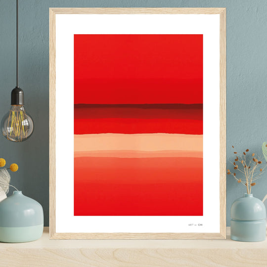 Lámina abstracta de líneas degradadas en tonos rojos y anaranjados, enmarcada con madera clara, colocada sobre un mueble de madera