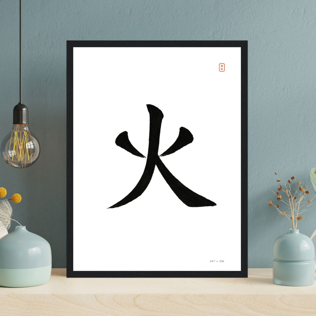 Carácter chino «火» (fuego) en tinta negra sobre fondo blanco, sello rojo y marco de madera negra.